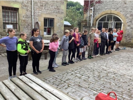 Primary school pupils standing in a row in a cobbled courtyard