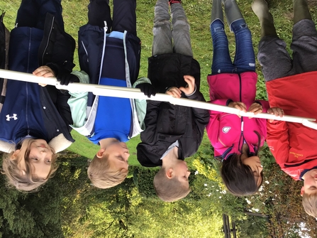 Children in a row taking part in a team building activity