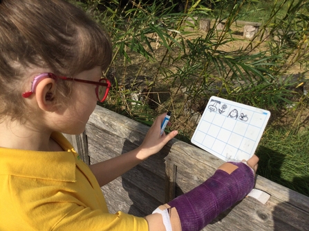Pupil looking at a reference card while studying outdoors