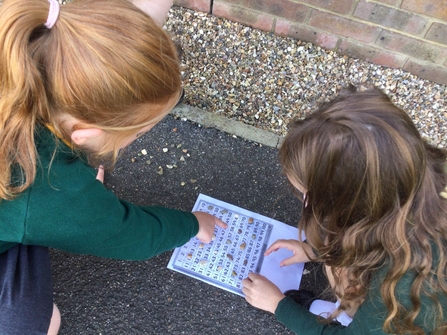 Two pupils undertaking learning outdoors 